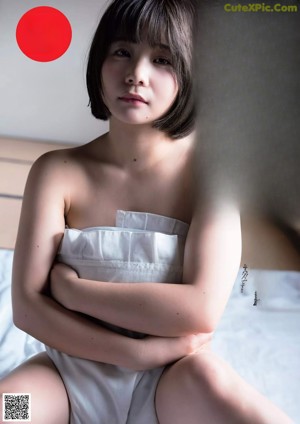 A woman in a lingerie standing in front of a window.