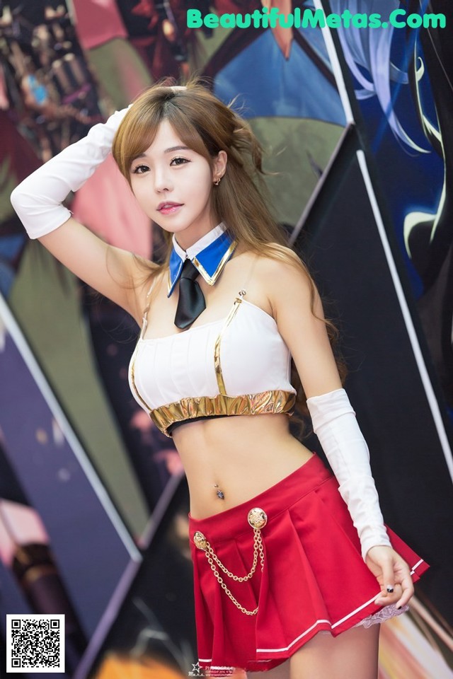 A woman in a white top and red skirt posing for a picture.