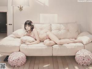 A girl sitting on a bed in a white dress.