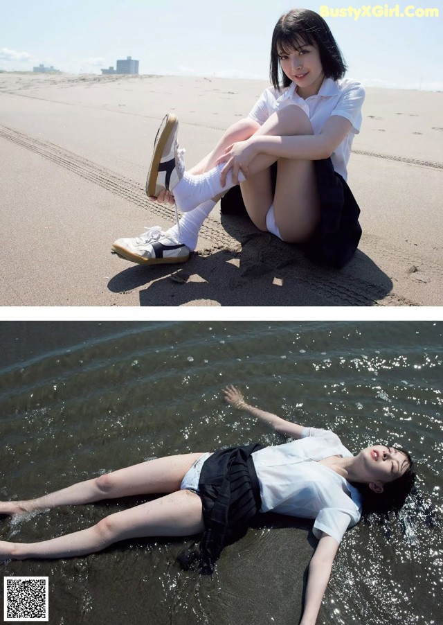 A woman laying on the beach with her legs in the water.