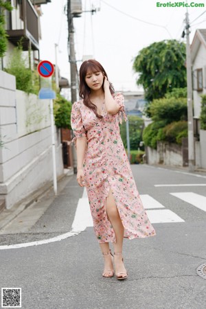 A woman in a pink robe is posing for a picture.