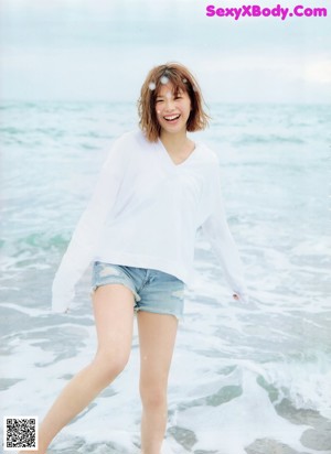 A woman in a blue and white striped top and shorts.