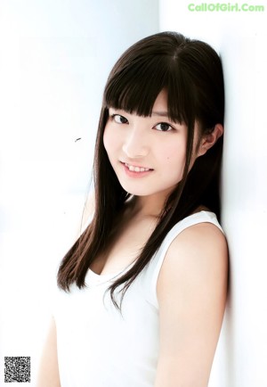 A woman in a blue tank top and gray shorts posing for a magazine.