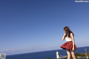 A woman in a white bikini posing on a wooden deck.