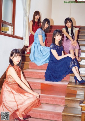 A group of young women sitting on top of a bed.