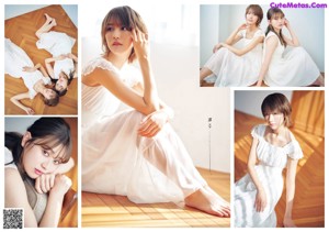 A woman in a white dress sitting on a wooden floor.
